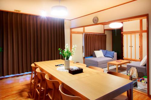 een woonkamer met een tafel en een bank bij KazeVillaFurano in Furano
