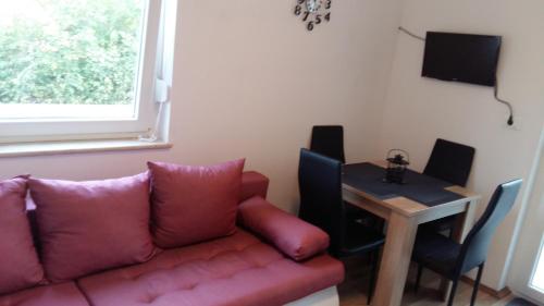 a living room with a red couch and a table at Apartment Adriatic in Umag