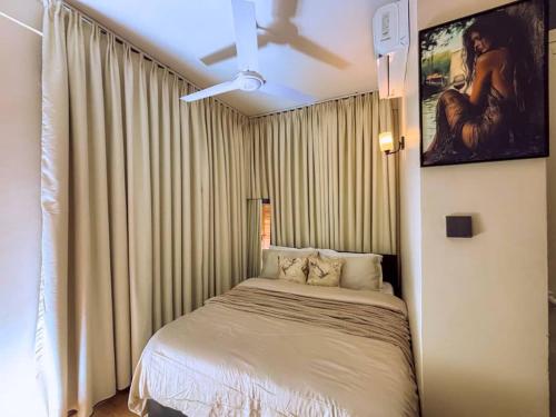 una camera da letto con un letto e un ventilatore a soffitto di Cozy stay a Dar es Salaam