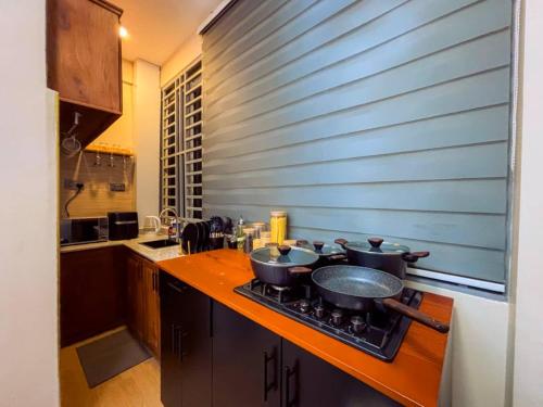 una cucina con piano cottura e 3 pentole sopra di Cozy stay a Dar es Salaam