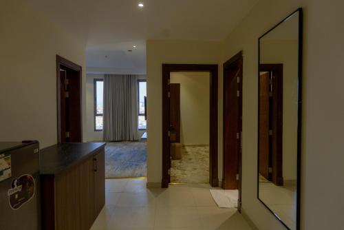 een keuken met een deur die leidt naar een gang met een spiegel bij فندق بالم بوتيك النهضة in Jeddah