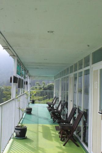 a row of chairs sitting on a balcony at Wong Pai Ton Villa in Ngadisari
