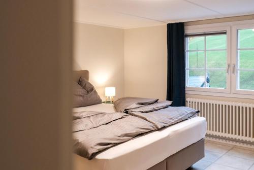 een ongemaakt bed in een kamer met een raam bij DASCO Isenthal in Isenthal