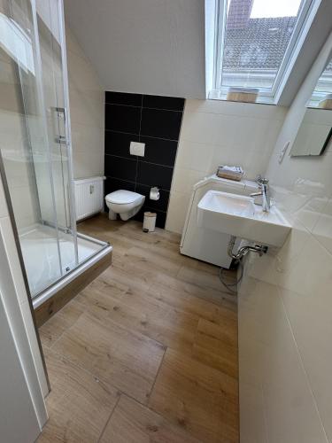 ein Badezimmer mit Toilette, Waschbecken und Dusche in der Unterkunft Kato Suite in Oldenburg
