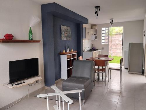 a living room with a television and a dining room at Cozy House with Private Garden in Pachuca in Pachuca de Soto