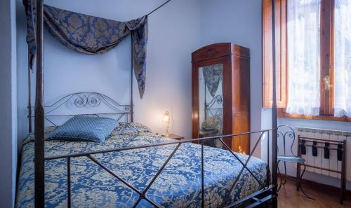 a bedroom with a bed with a blue bedspread at Hotel Torre Guelfa Palazzo Acciaiuoli in Florence