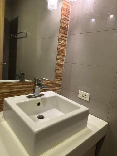 a bathroom with a white sink and a mirror at CAROLA in Pico de Loro in Nasugbu