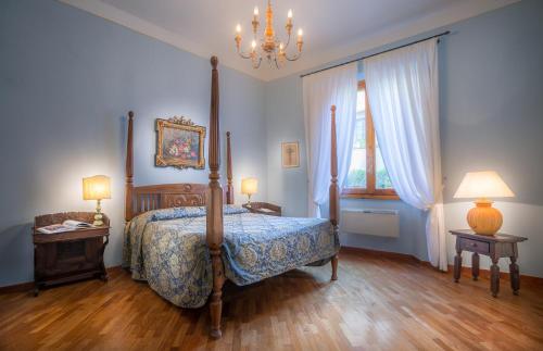 a bedroom with a bed and two tables and a chandelier at Hotel Torre Guelfa Palazzo Acciaiuoli in Florence