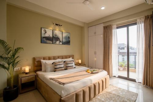 a bedroom with a large bed and a large window at BedChambers Serviced Apartment, Medicity in Gurgaon