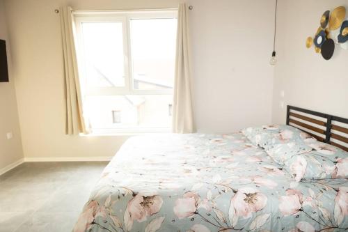 a bedroom with a bed with flowers on it at Maison MUGUET 2 SPA-PARKING-COLMAR in Wickerschwihr