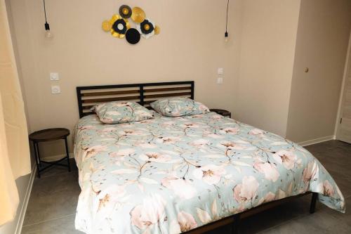 a bedroom with a bed with pink flowers on it at Maison MUGUET 2 SPA-PARKING-COLMAR in Wickerschwihr