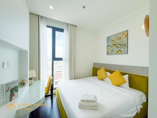een slaapkamer met een bed met gele kussens en een raam bij The Hillside Seaview Apartment Phu Quoc in Phu Quoc