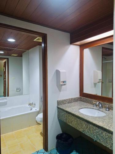 a bathroom with a sink and a tub and a mirror at Successive BeachFront ,Krabi in Ban Khlong Haeng