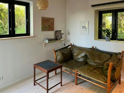 a living room with a couch and a table at Sommerhus Med Udsigt Over Dalbybugten in Mesinge