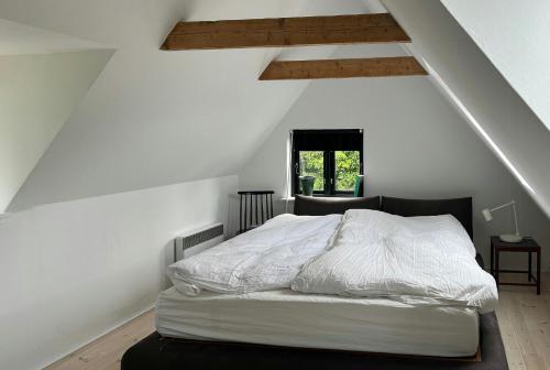 1 dormitorio con 1 cama blanca en el ático en Holiday Home With View Of Dalby Bay, en Mesinge