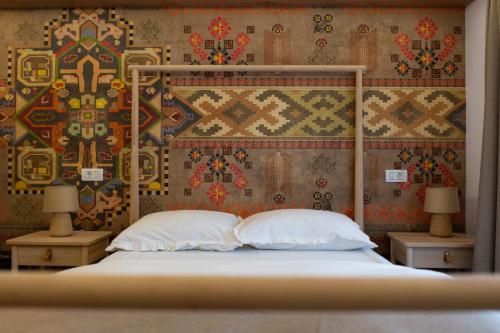 a bedroom with a bed with two pillows and a wallpaper at MonteRai in Văliug