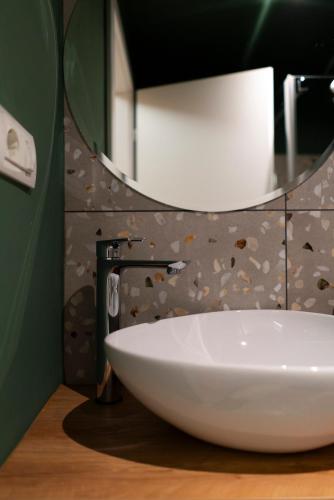 a bathroom with a white sink and a mirror at MonteRai in Văliug