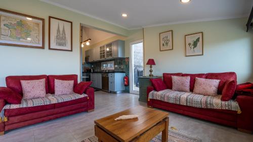 a living room with two red couches and a table at The Goat's Place III in Gaula