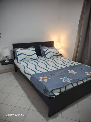 a bed with a blue comforter with stars on it at WHITE FLAT ALMADIES in Dakar