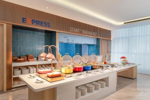 uma fila de bufê com comida em exposição em um restaurante em Holiday Inn Express Langfang Sanhe by IHG em Sanhe