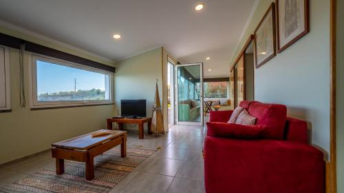a living room with a red couch and a table at The Goat's Place III in Gaula