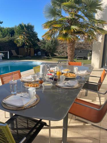 a table with food on it next to a pool at Comme une évidence in La Chapelle aux Pies