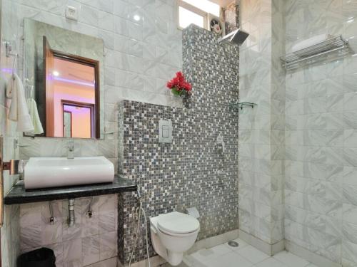 a bathroom with a toilet and a sink and a mirror at Hotel Sehej Continental At Karol Bagh in New Delhi