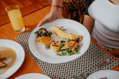 a person sitting at a table with a plate of food at Parigata Villas Resort in Sanur