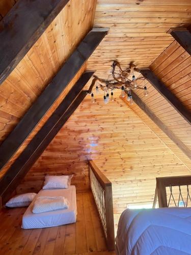 a attic with two beds in a wooden room at Dreamy Garden Cabin in Gundauri
