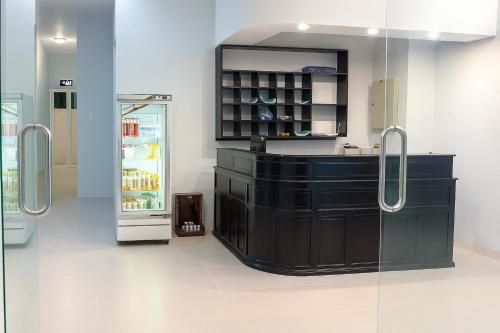a kitchen with a black counter and a refrigerator at Đại An Hotel Bến Tre in Ben Tre