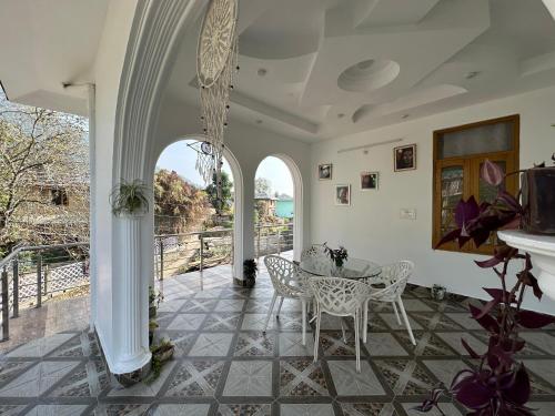 Un comedor con mesa y sillas en un patio. en La Casa by Cosmic Kriya, en Bīr