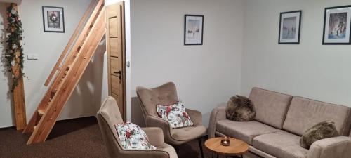 a living room with a couch and two chairs at Penzion Branná in Branná