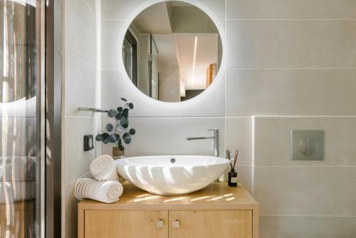 een badkamer met een witte wastafel en een spiegel bij Vinothea Vista in Kefallonia