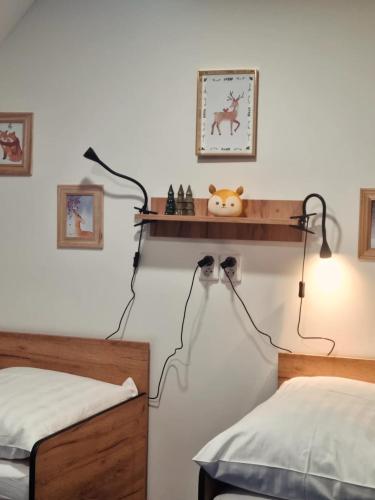 a bedroom with two beds and a shelf on the wall at Penzion Branná in Branná