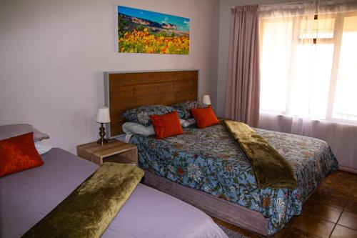 a hotel room with two beds and a window at Maskam Guest Farm in Vanrhynsdorp
