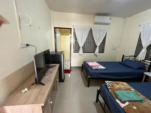 a room with two beds and a television in it at ทองอุไรโฮมสเตย์ ณ แม่สาย in Mae Sai