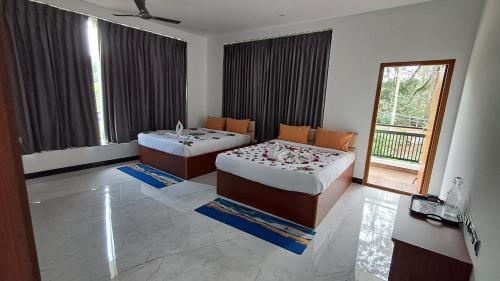 a bedroom with two beds and a window at Forest Abode in Yercaud