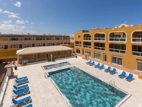 an overhead view of a pool with chairs and a building at My little paradise in Cotillo