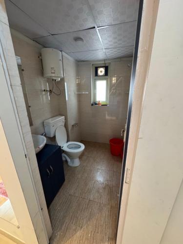 a small bathroom with a toilet and a window at Khokhar studio in Karnal