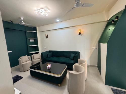 a living room with a green couch and chairs at Khokhar studio in Karnal