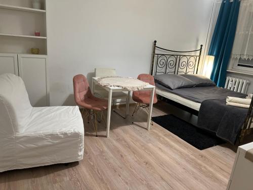 a bedroom with a bed and a table and chairs at Apartament Przytulny przy plaży in Sopot
