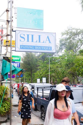 a group of people walking down a sidewalk under a sign at Silla Patong Boutique - Beach Walk Access in Patong Beach