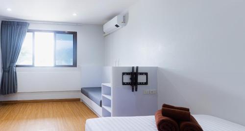 a white bedroom with a bed and a window at Silla Patong Boutique in Patong Beach