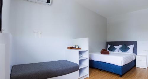 a bedroom with two beds and a bench in it at Silla Patong Boutique in Patong Beach