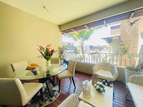 Domaine Des Alizees Residence في غراند بايَ: غرفة طعام مع طاولة وكراسي وشرفة