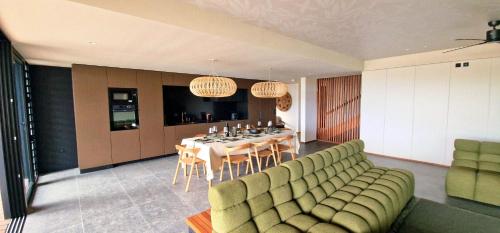 a living room with a table and a dining room at Le Domaine des Manguiers in Saint-Gilles les Bains
