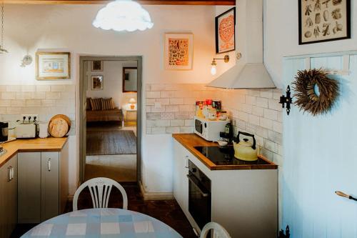 a kitchen with a table and a stove top oven at Kiskovász Pajta & Inn in Nagytevel