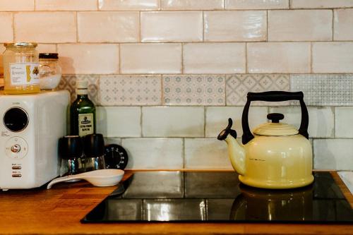 a yellow tea kettle sitting on a stove in a kitchen at Kiskovász Pajta & Inn in Nagytevel