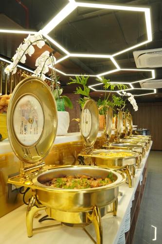 uma fileira de travessas de comida em um buffet em Bcons City Hotel em Dĩ An