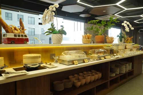 uma cozinha com um balcão com pratos e pratos em Bcons City Hotel em Dĩ An